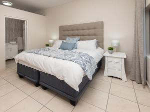 马盖特The Beach Palace Ramsgate的卧室设有一张大床,铺有白色的地板。