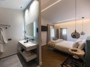 锡古恩萨INFINITVM的一间卧室配有床、水槽和镜子
