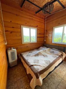 考科Elevated Serenity Lodge in Khao Kho的小木屋内一间卧室,配有一张床