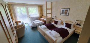 安斯巴赫凯斯巴克穆尔酒店的一间卧室配有一张床、一张沙发和一把椅子