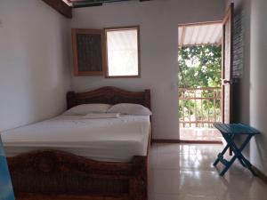 巴尔Hostal El Nido del Azulejo的一间卧室设有一张床、一个窗口和一把椅子