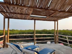 巴尔Hostal El Nido del Azulejo的一个带椅子的庭院、一个游泳池和一个木制屋顶