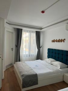伊兹密尔Urla Marin otel的一间卧室配有一张大床和蓝色床头板