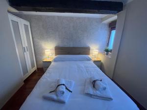 La Escapada的一间卧室配有一张带毛巾和两盏灯的床。