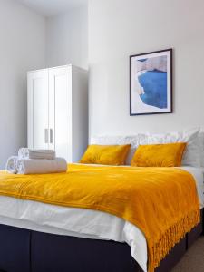 北安普敦Palatial Six Bedroom Haven的一间卧室配有一张带黄色毯子的大床