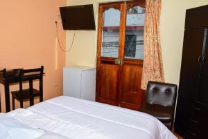 阿亚库乔Hotel Santa Ana的一间卧室配有一张床、一个窗口和一张书桌