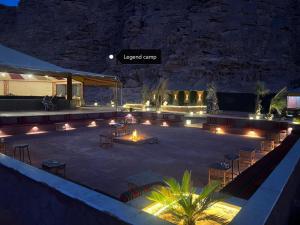 瓦迪拉姆Rum Legend camp的一个带灯光和桌椅的庭院