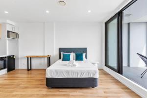 奥克兰Manukau Studio Apartments的一间卧室配有一张带蓝色枕头的大床