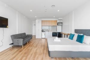 奥克兰Manukau Studio Apartments的客厅配有大床和沙发