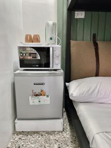 宿务Cebu Backpackers Hostel的床铺旁冰箱的微波炉