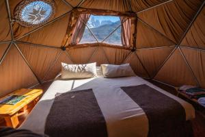 百内三塔巴塔哥尼亚生态露营酒店的蒙古包内带床的房间,带窗户