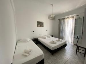 迈洛波塔斯深蓝客房和公寓公寓式酒店的白色墙壁客房的两张床