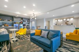 霍玛Comfort Inn & Suites Houma的客厅配有蓝色的沙发和黄色的椅子