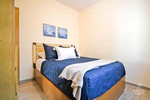 拉巴斯NEW Comfy Stay with Pool Onsite Steps from Malecón的一间卧室配有一张带蓝色床单和枕头的床。