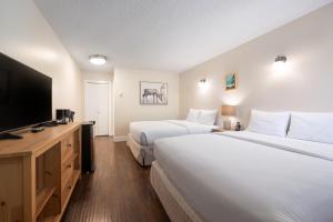 伦弗鲁港West Coast Trail Lodge的酒店客房设有两张床和一台平面电视。