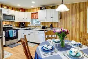 BurnsvilleRiverfront North Carolina Abode with Deck and Fire Pit的厨房配有白色橱柜和鲜花桌