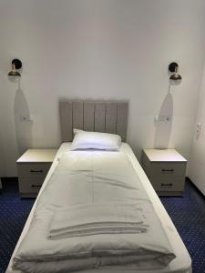 曼兴Gastpark Hotel的一间卧室配有一张带2个床头柜的大床