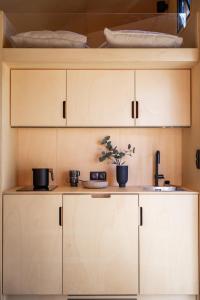 Modern Tiny House的厨房配有白色橱柜和水槽