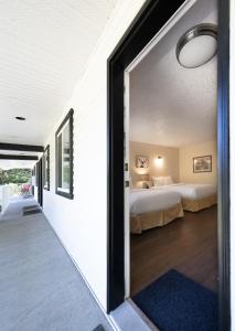 伦弗鲁港West Coast Trail Lodge的带两张床的房间和一间带窗户的卧室