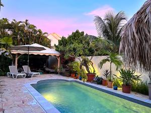 勒拉芒坦Sweet Payot : Studio avec Spa privé et piscine的棕榈树庭院内的游泳池