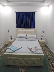 阿加迪尔Your House For Family的一间卧室设有一张大床和蓝色窗户