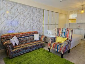 内罗毕Airport Studio Apartments-JKIA的客厅配有两把椅子和一张沙发