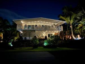 Hawaiian Paradise ParkStunning Ocean Views - Whale House Hawaii的一间晚上有灯的白色房子