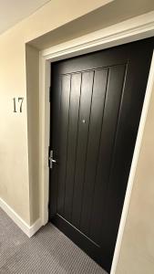 伦敦Modern & stylish 1 bedroom flat的一间房间的角落里有一个黑色的门