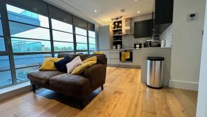 伦敦Modern & stylish 1 bedroom flat的一间带棕色沙发的客厅和一间厨房