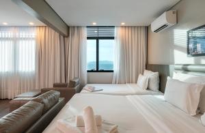 弗洛里亚诺波利斯蓝树高级弗洛里亚诺波利斯旅馆的酒店客房,设有两张床和一张沙发
