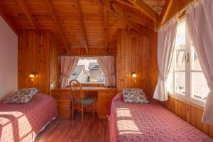 圣马丁德洛斯Sol y Nieve的一间卧室设有两张床、一张桌子和一个窗口。