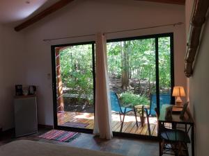 San José PinillaBaliyana Lodge的一间设有滑动玻璃门的客房,可通往庭院