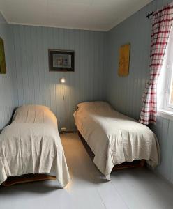 斯塔姆松Charming Rorbu Stamsund Lofoten的一间卧室设有两张床和窗户。