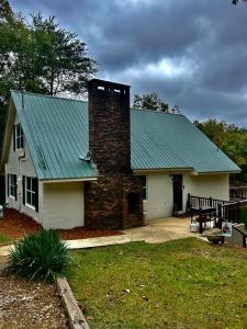 Crane HillBest Life Now Cottage的一座带砖烟 ⁇ 的绿色屋顶的房子