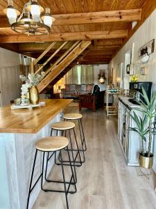 Crane HillBest Life Now Cottage的厨房以及带木制天花板和凳子的客厅。