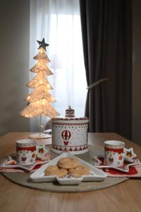 卡鲁德杰尔斯科巴尔MB APARTMAN TARA的一张桌子,上面有圣诞蛋糕和饼干,还有圣诞树