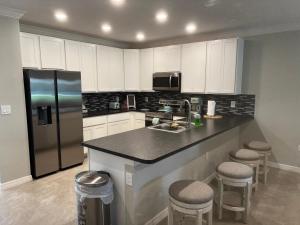 基西米Luxurious Farm Style House的厨房配有水槽、冰箱和凳子