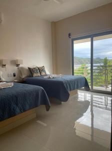 恰卡拉Villanueva Suite’s的一间卧室设有两张床和大窗户