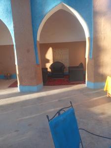 扎古拉Riad Tagmadarte Ferme d'Hôte的一间设有两把椅子和蓝色墙壁的房间