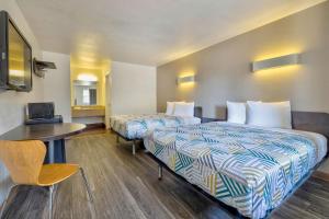布赖恩布莱恩大学城6号汽车旅馆的酒店客房设有两张床和一张桌子。