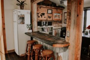 FredoniaRustic Ranch Getaway Near Zion, Bryce, Grand Canyon的厨房设有带凳子和冰箱的酒吧。