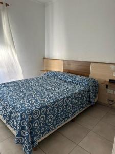 雷西斯膝西亚HOTEL DIAMANTE的卧室内的一张带蓝色和白色棉被的床