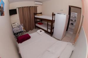 佩尼亚Pousada Esperança的小房间设有一张床和一台冰箱