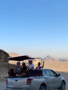瓦迪拉姆Yellow Star Camp Wadi Rum的一群人骑在卡车后面