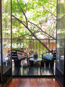 布宜诺斯艾利斯Te invito a Compartir mi Depto. Artlovers. Solo Damas.的阳台配有两把椅子和一张桌子,还有一棵树