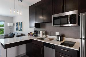 加尔维斯敦Residence Inn by Marriott Galveston Island的厨房配有黑色橱柜和不锈钢用具
