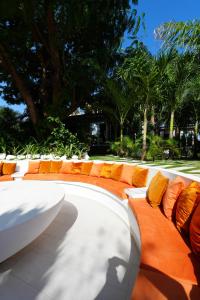 阿克拉Lukas Garden Accra的长凳上摆放着橙色和白色的枕头