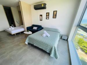圣玛尔塔Salguero Suites - Playa Salguero - By INMOBILIARIA VS的一间卧室配有一张床、一张沙发和一个窗口