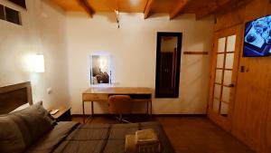 圣佩德罗·德·阿塔卡马Hostal Yurak的客房设有书桌、床和桌子。