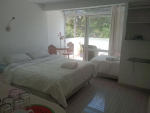 利马Monterrico Suites Hotel的一间卧室设有两张床、一张桌子和一个窗口